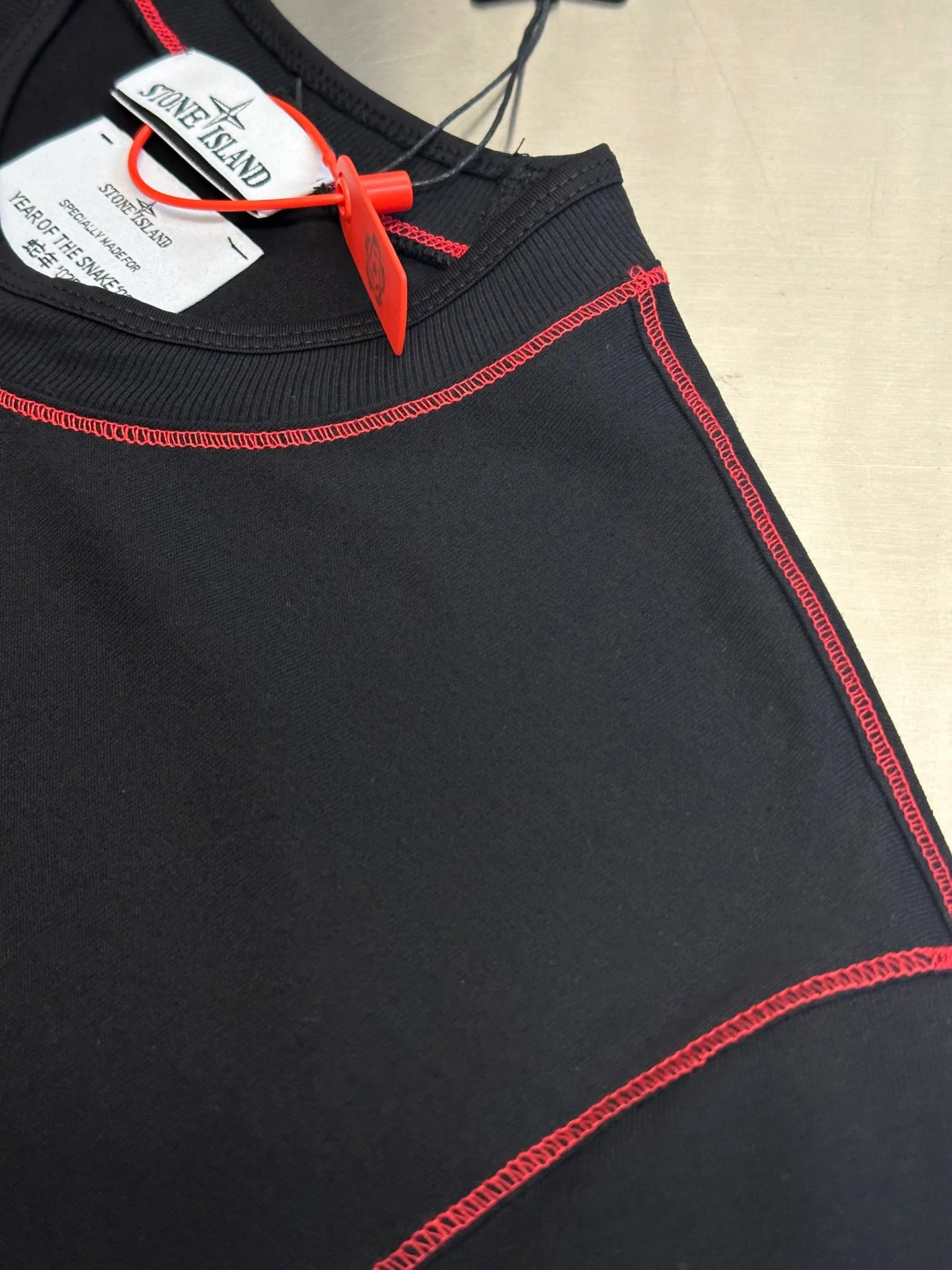 🅿️270 Stonelsland Badge Embroidered Short Sleeves Customized elegant black silk cotton and linen plain fabric, with iconic red Compass badge embroidery on the chest, stitching art, and the beauty of contrasting colors. The red stitches jump on the black base. The collision of fashion and creativity exudes irresistible charm. Imported machine embroidery technology is used, and advanced computer control systems and precision mechanical components are used to realize the red Compass badge embroidery operation. Special machine for reverse topstitching and fine sewing process. Special machine is used for topstitch sewing. It requires careful preparation of the reverse side of the garment before sewing to ensure that the sewing lines are straight, the stitches are even, and the edges are smooth and beautiful.  size：s m l xl